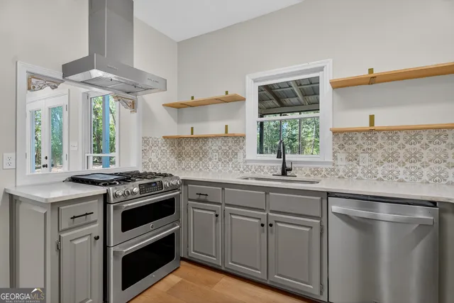 a kitchen with granite countertop a sink stainless steel appliances and cabinets