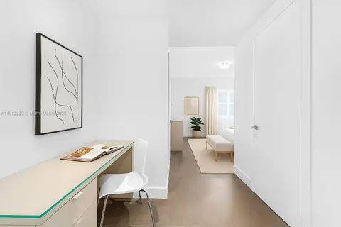 a view of a hallway that has a table and chairs