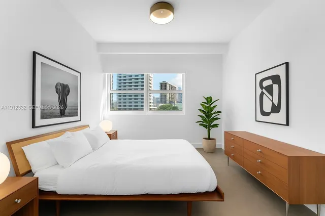 a bedroom with a bed and a painting on the wall