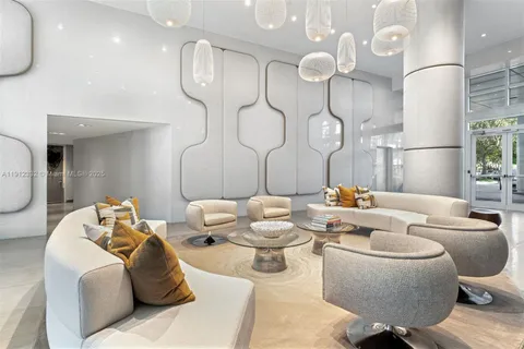 a living room with furniture kitchen view and a chandelier