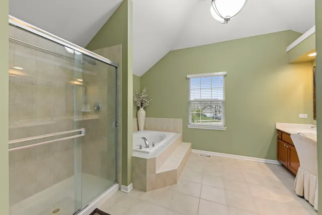 a spacious bathroom with a tub sink and mirror