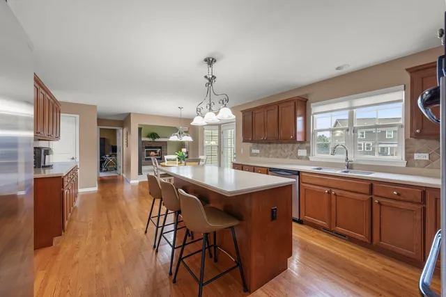 a kitchen with stainless steel appliances granite countertop wooden floors and white cabinets