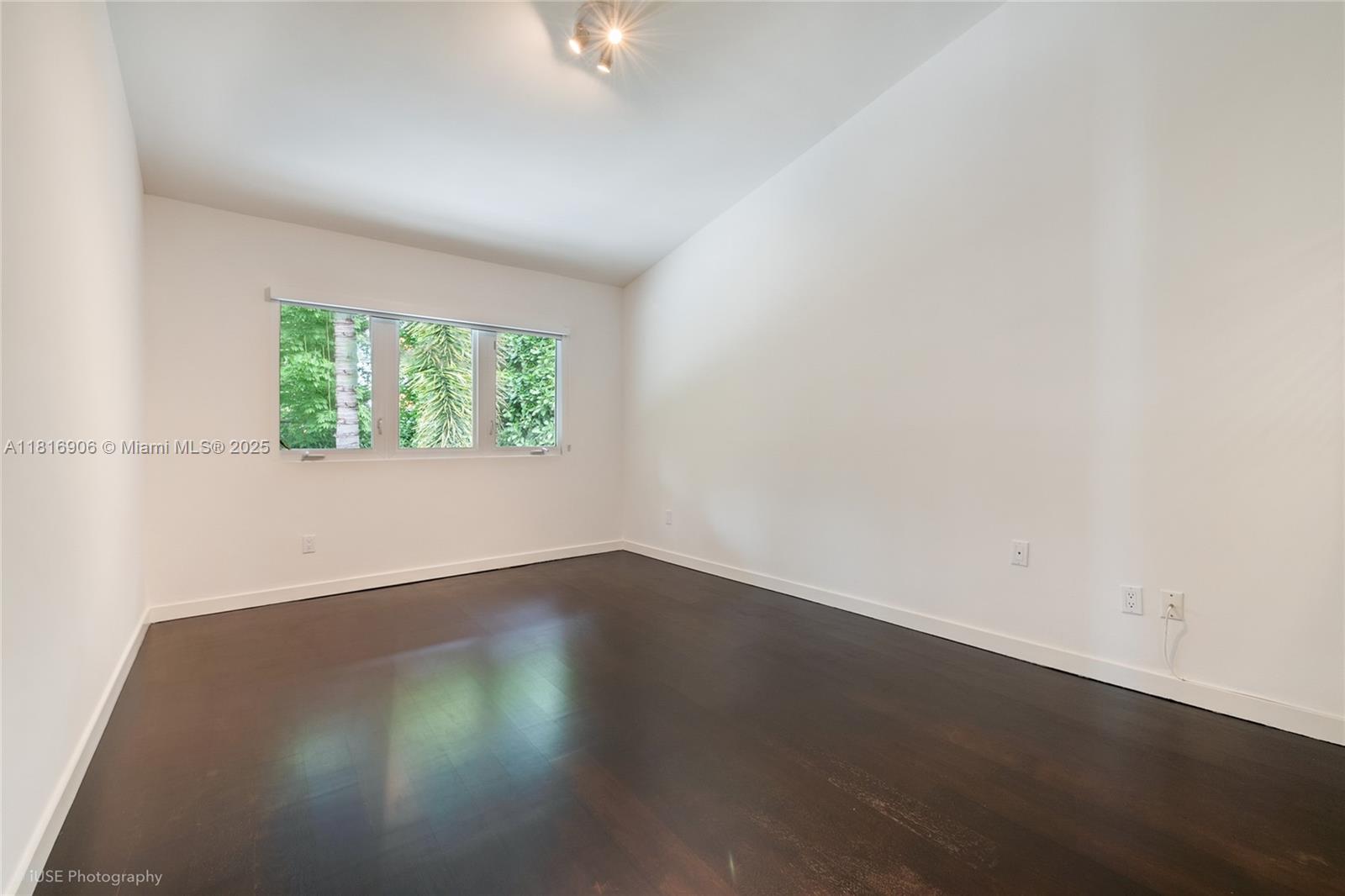 230 Ridgewood Road Coral Gables, FL 33133 - Photo 12 of 19 an empty room with wooden floor and windows