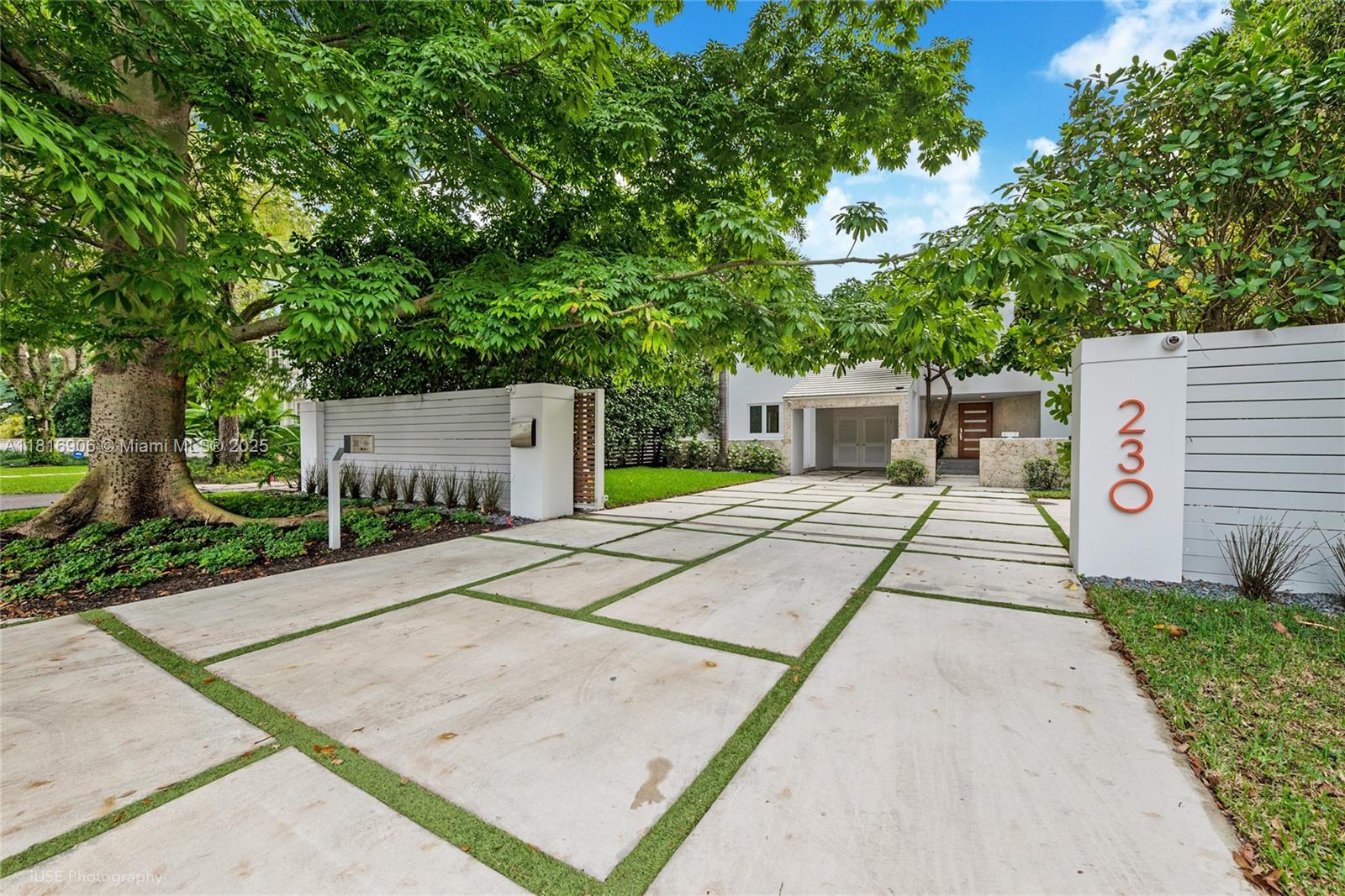 230 Ridgewood Road Coral Gables, FL 33133 - Photo 2 of 19 a view of a white house with a yard and potted plants