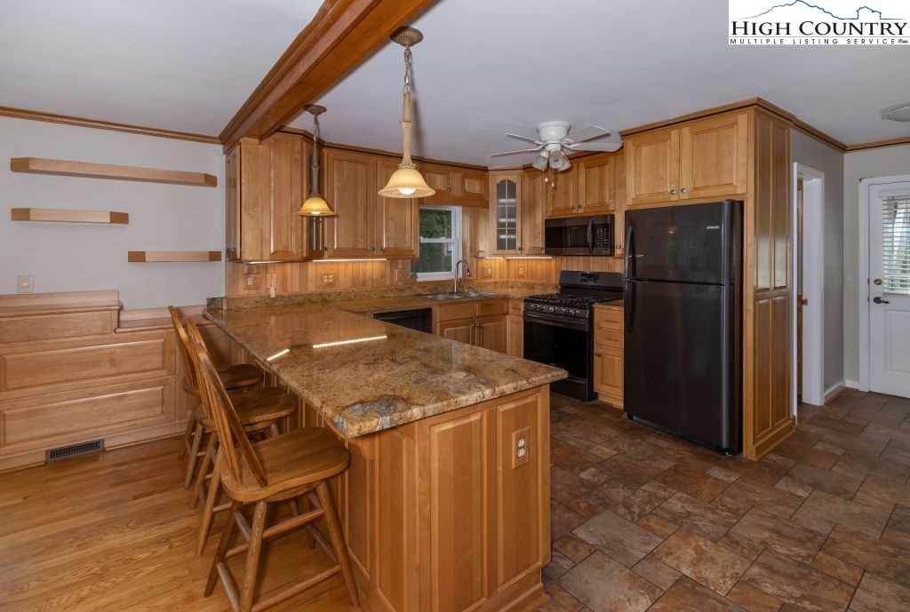 1005 Andy Hicks Road Banner Elk, NC 28604 - Photo 10 of 44 a kitchen with stainless steel appliances kitchen island granite countertop dining table chairs and granite counter tops