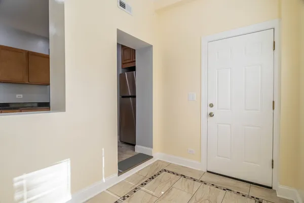 a view of a hallway with wooden floor and a bathroom