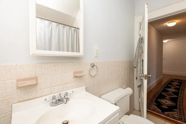 a bathroom with a sink a vanity and a shower curtain