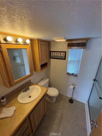 a bedroom with a bed a flat tv screen and on a dresser