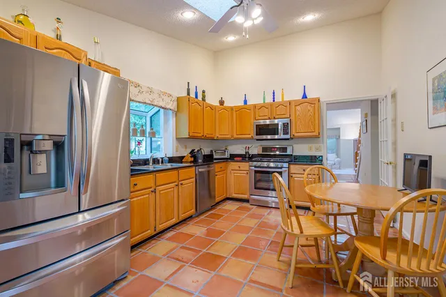a kitchen with stainless steel appliances kitchen island granite countertop a refrigerator and a stove top oven