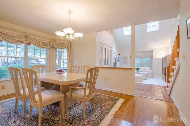 a kitchen with stainless steel appliances granite countertop a stove a sink dishwasher a dining table and chairs with wooden floor