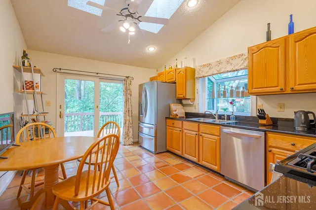 a kitchen with stainless steel appliances kitchen island granite countertop a refrigerator and a stove top oven
