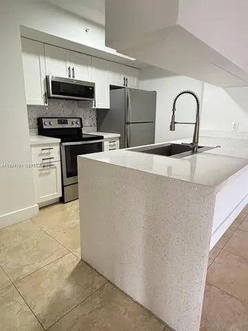 a kitchen with stainless steel appliances and a refrigerator