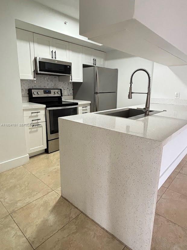 a kitchen with stainless steel appliances and a refrigerator