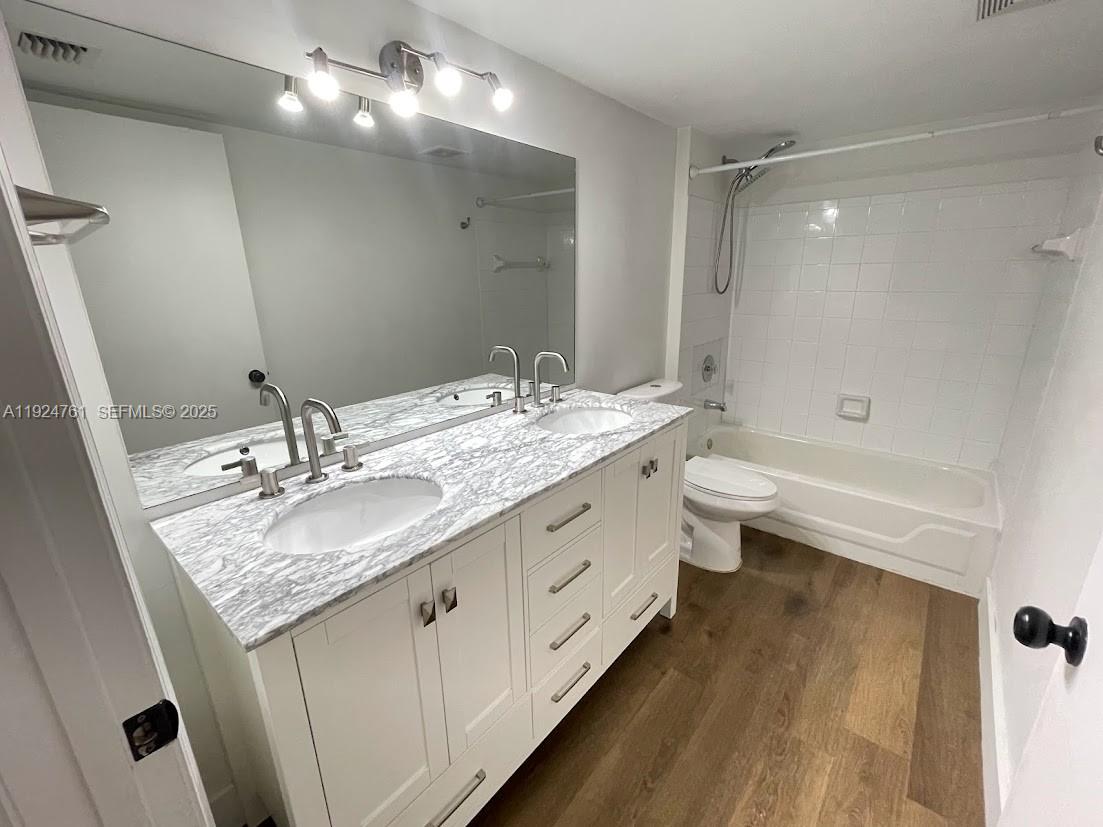 410 South Park Road, Unit 207 Hollywood, FL 33021 - Photo 33 of 47 a bathroom with a granite countertop double vanity sink a toilet and a mirror