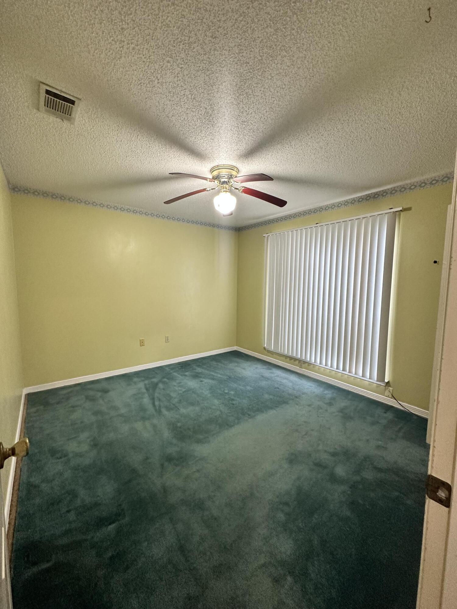 128 Dolphin Cove Freeport, FL 32439 - Photo 18 of 36 an empty room with a ceiling fan and carpet