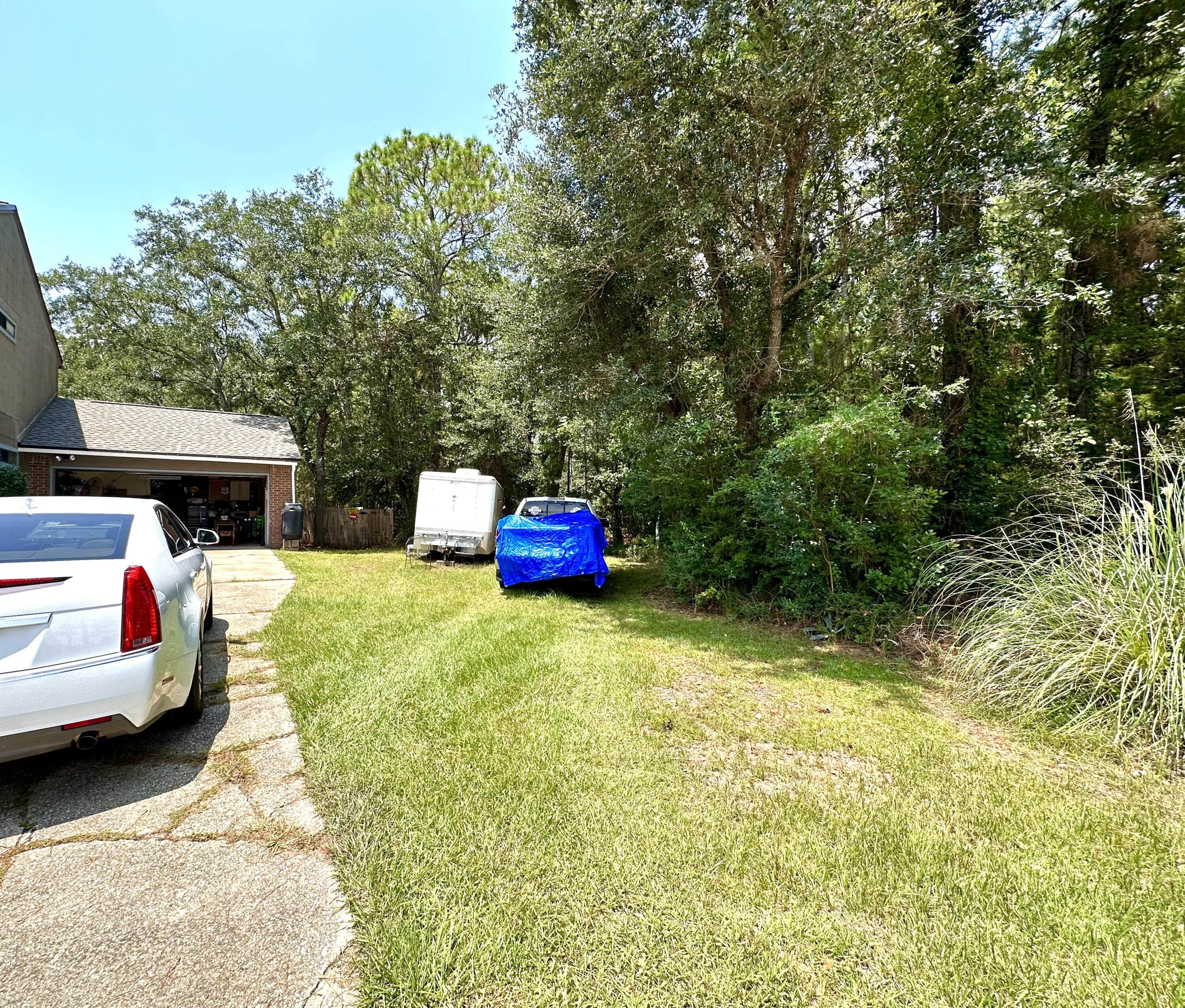 128 Dolphin Cove Freeport, FL 32439 - Photo 9 of 36 a backyard of a house with couches plants and large trees
