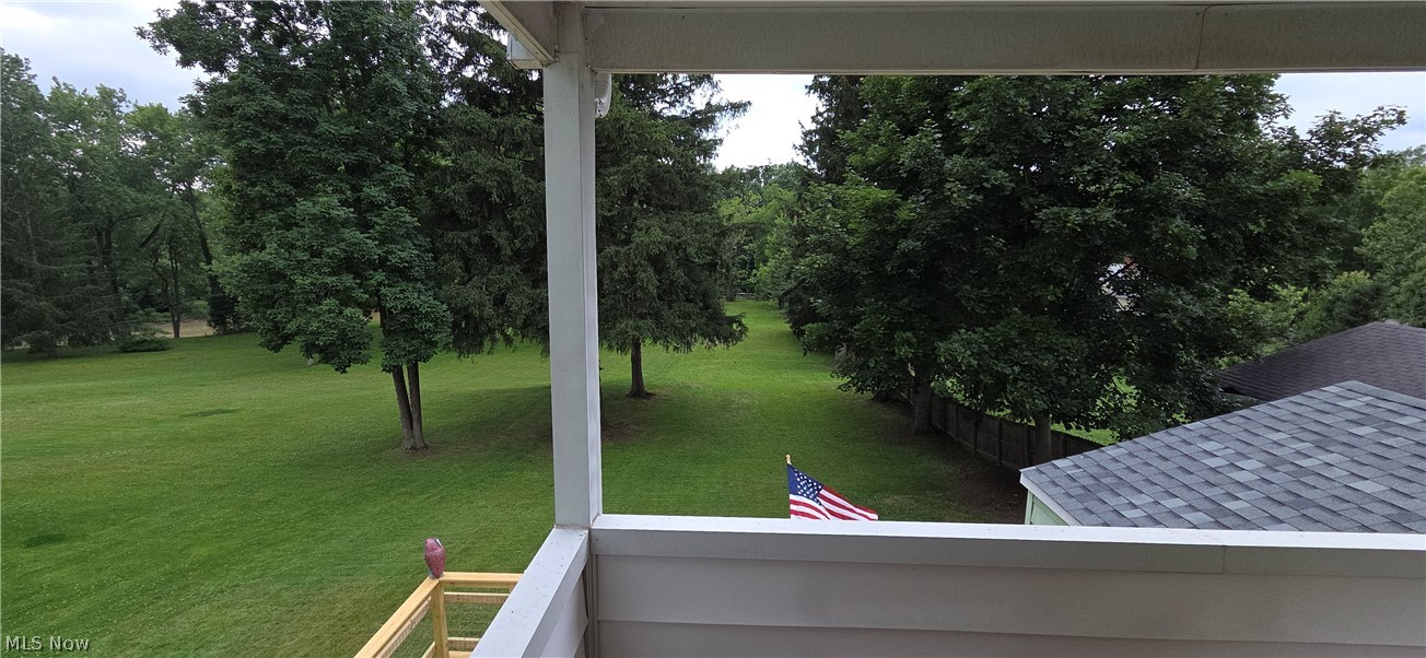9964 East River Road Elyria, OH 44035 - Photo 30 of 45 View from the private balcony featuring the Black River, with expansive green lawn framed by mature trees, offering an open outdoor space