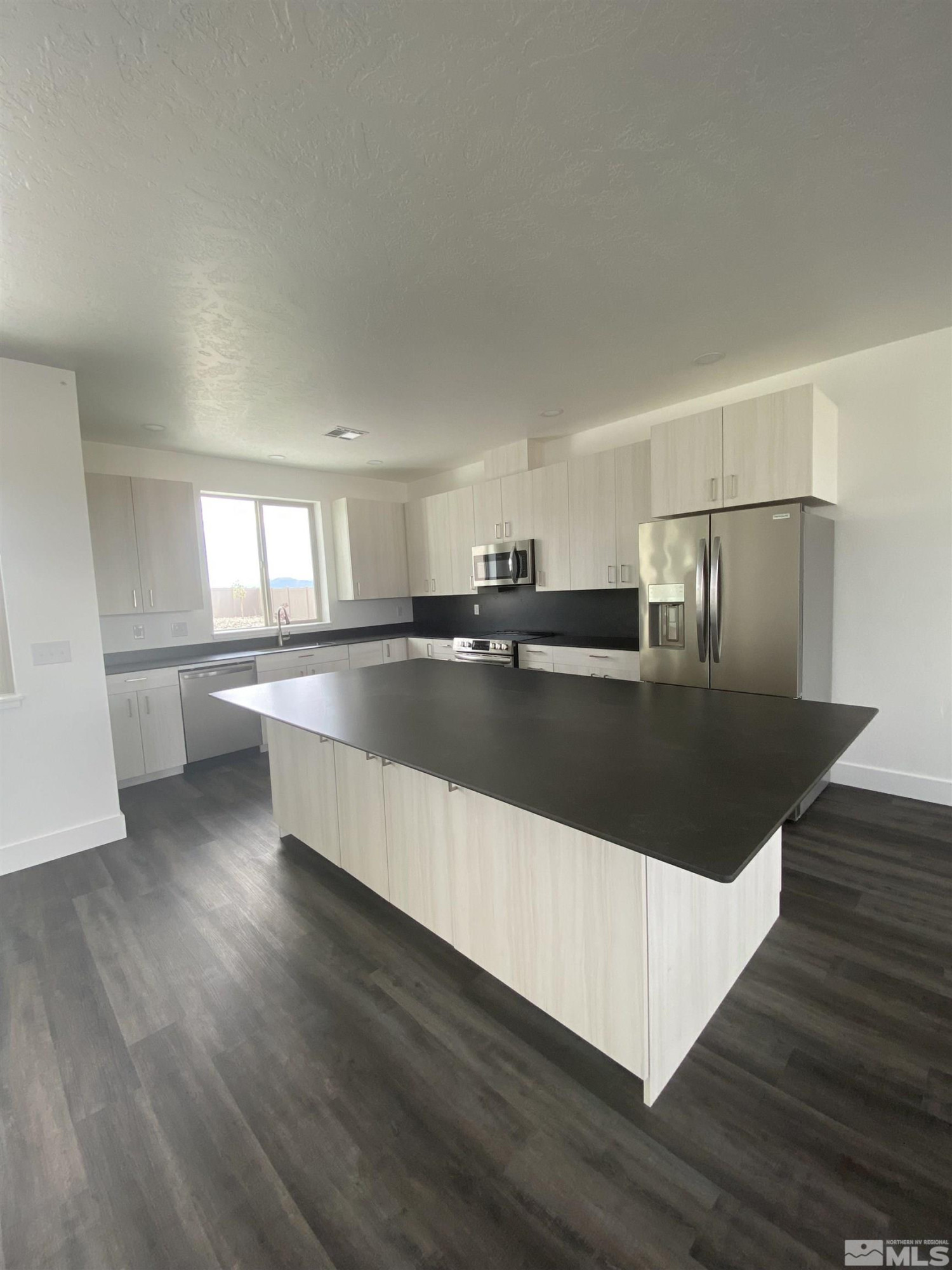 5950 Packsaddle Road Winnemucca, NV 89445 - Photo 4 of 14 a large kitchen with stainless steel appliances granite countertop a large counter top and wooden floor