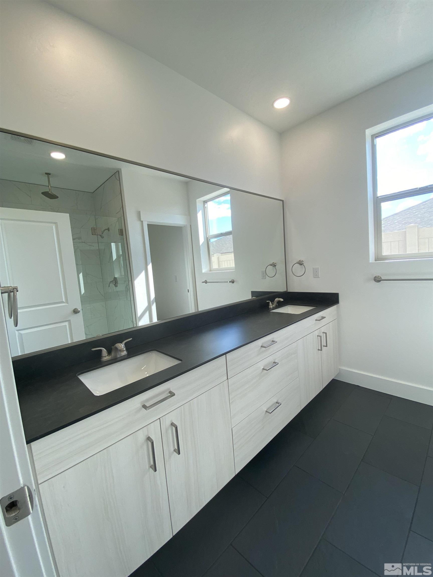 5950 Packsaddle Road Winnemucca, NV 89445 - Photo 7 of 14 a spacious bathroom with a granite countertop sink and a mirror