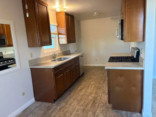 a kitchen with a sink a stove and cabinets