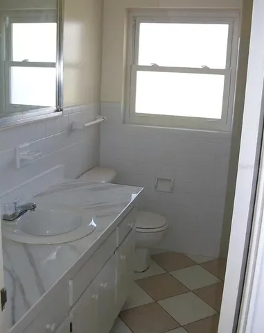 a bathroom with a toilet a window and a shower