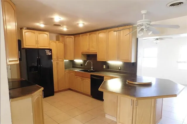 a kitchen with stainless steel appliances granite countertop a sink refrigerator and cabinets