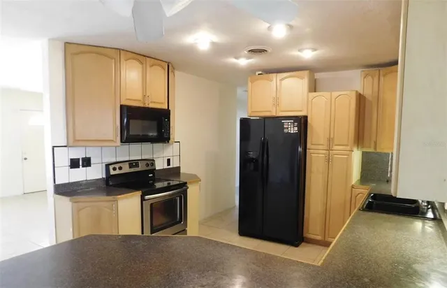 a kitchen with a refrigerator and a stove top oven