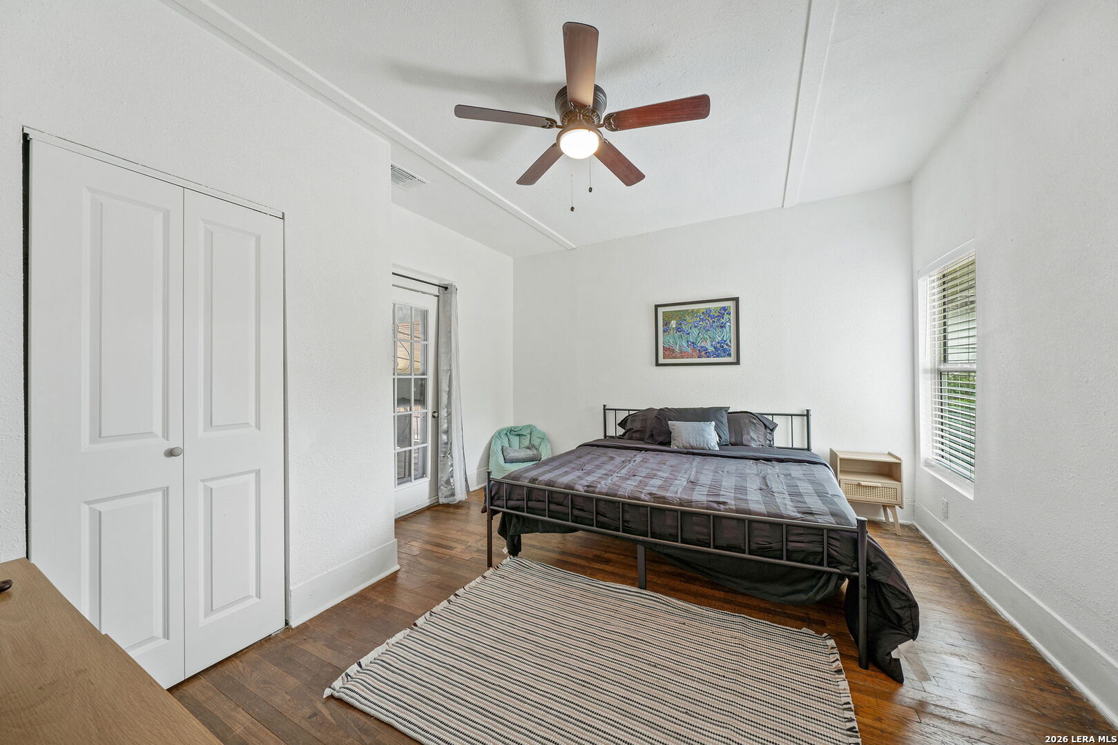 636 Rigsby Avenue San Antonio, TX 78210 - Photo 13 of 23 a bedroom with a bed and wooden floor