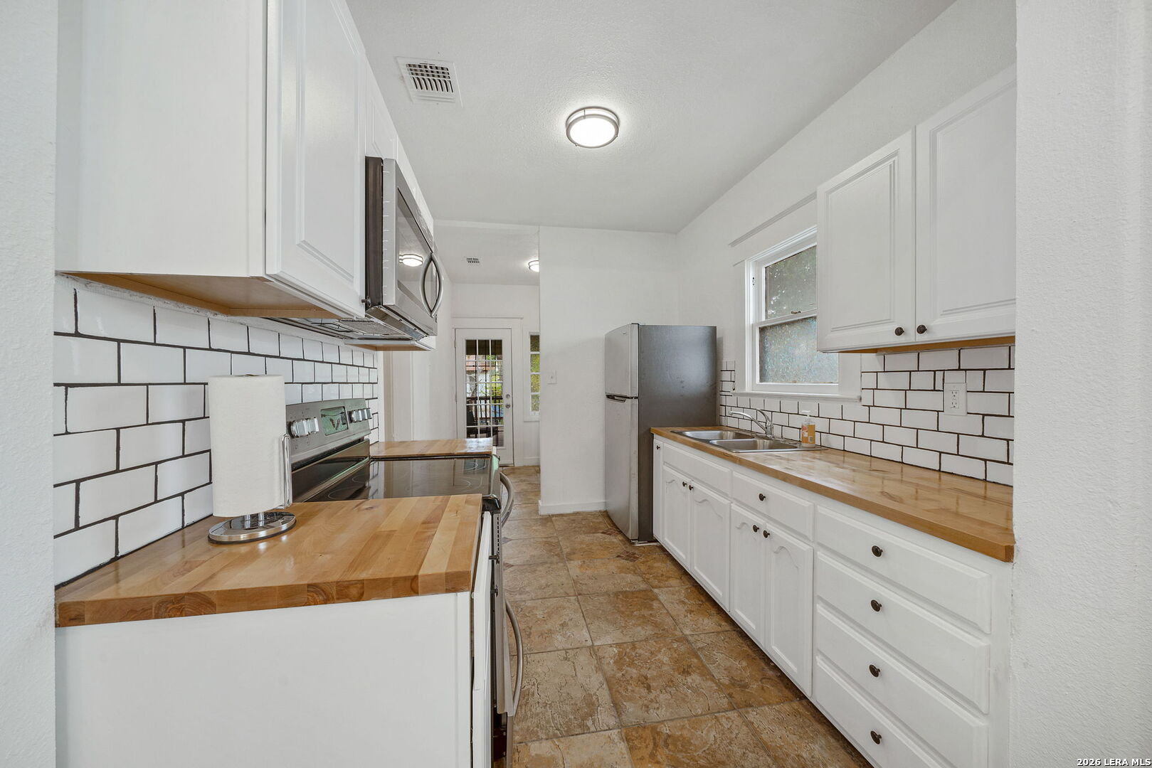 636 Rigsby Avenue San Antonio, TX 78210 - Photo 7 of 23 a kitchen with stainless steel appliances kitchen island granite countertop a refrigerator and stove