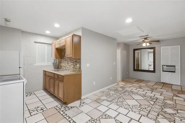 a view of an empty room with window and chandelier fan
