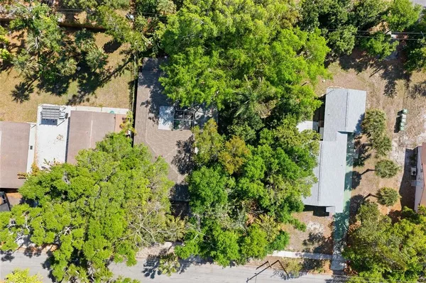 an aerial view of residential houses with outdoor space and trees