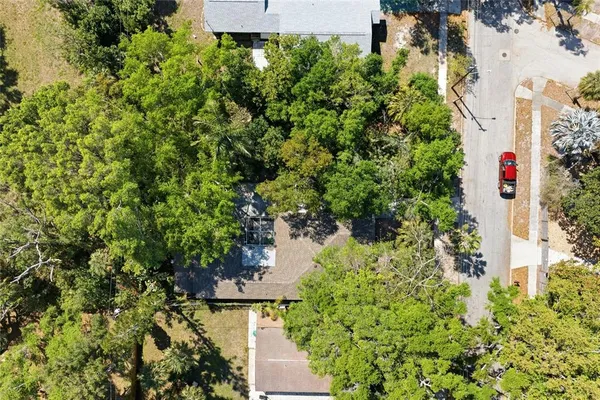 an aerial view of residential houses with outdoor space and trees