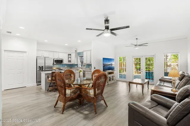a dining room with furniture a chandelier and wooden floor