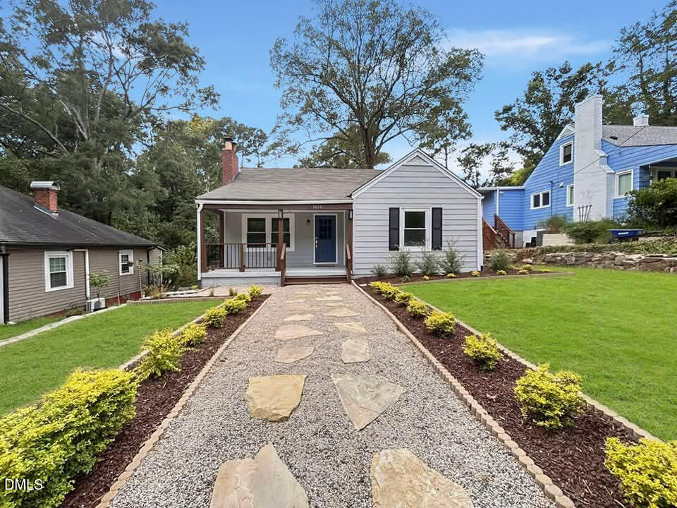 a front view of a house with a garden and trees