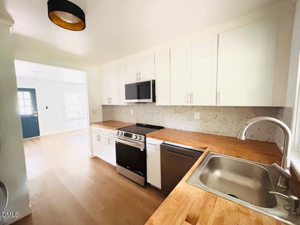 1606 James Street Durham, NC 27707 - Photo 14 of 24 a kitchen with granite countertop a sink and a stove top oven
