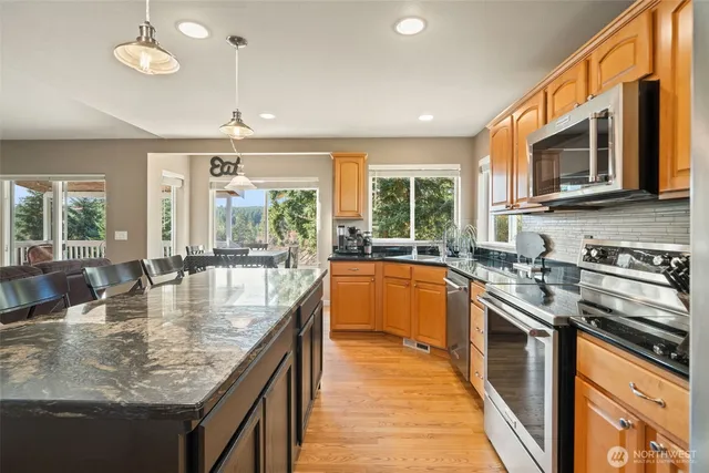 a large kitchen with stainless steel appliances granite countertop a sink a stove counter space and stainless steel appliances