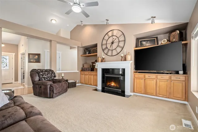 a living room with furniture a flat screen tv and a fireplace
