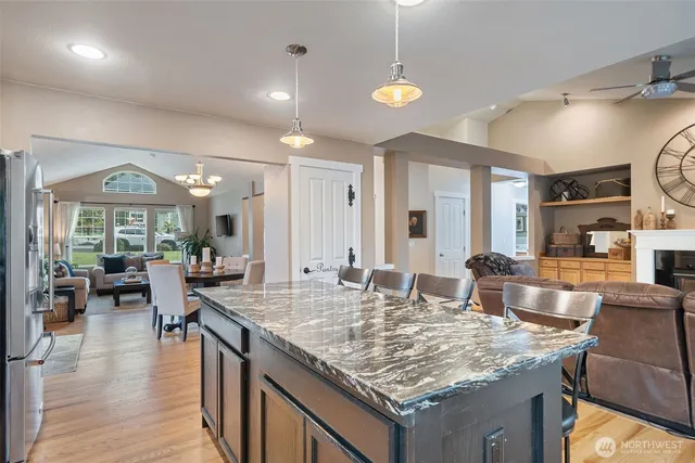 an open kitchen with granite countertop a table and chairs in it