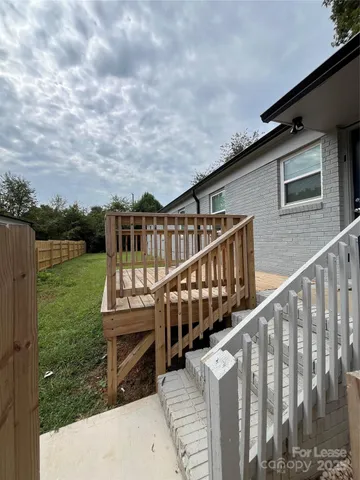a view of an house with backyard and deck