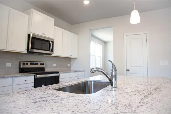 a kitchen with a sink a stove a microwave and island