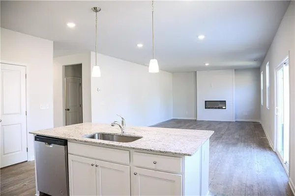 a view of kitchen island a sink wooden floor and living room