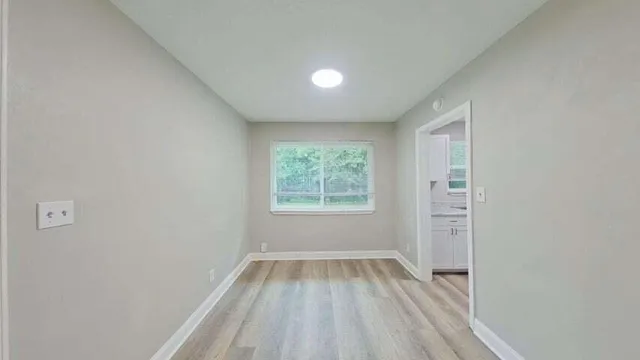 a view of a room with wooden floor and window