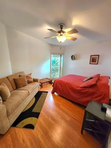 a bedroom with a bed and wooden floor