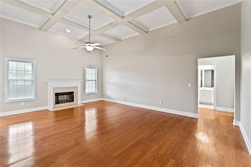 241 Red Bud Road Jefferson, GA 30549 - Photo 5 of 43 an empty room with wooden floor fireplace and windows