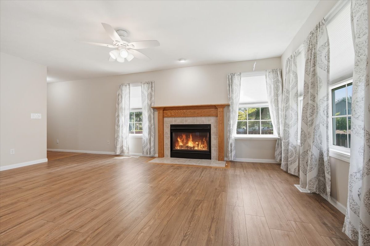 311 Old Farm Road Bloomington, IL 61704 - Photo 5 of 34 a view of an empty room with wooden floor fireplace and a window