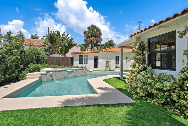 a view of a house with swimming pool and a yard