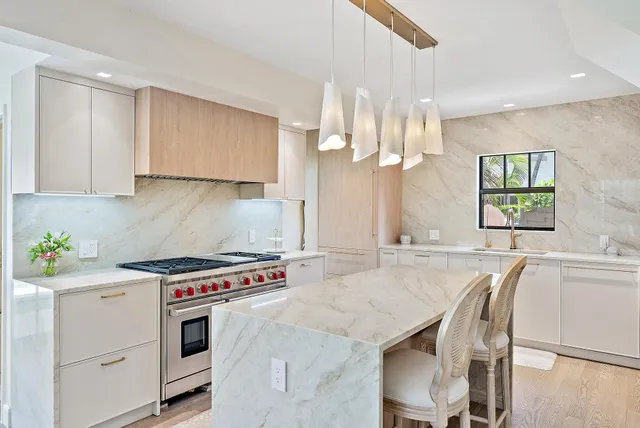 a kitchen that has a stove a table and chairs in it
