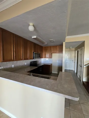 a kitchen with stainless steel appliances granite countertop a sink a stove and a refrigerator