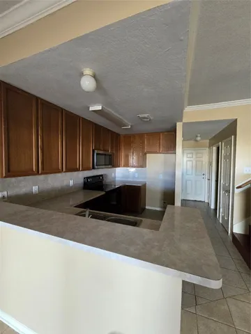 a kitchen with stainless steel appliances granite countertop a sink a stove and a refrigerator