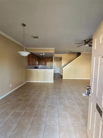 an empty room with windows and fan